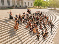 Gruppenfoto des Akademischen Orchesters auf der Freitreppe vor dem Löwengebäude (Bild öffnet vergrößert)