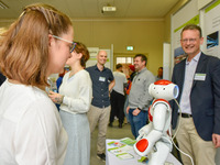 Am Infostand der Informatik begrüßt ein kleiner Roboter die Besucher. (Bild öffnet vergrößert)